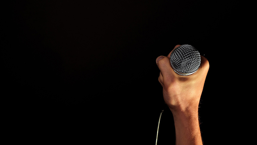 hand holding a microphone at a comedy club